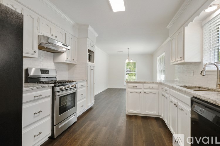 A modern kitchen with white cabinets and a black refrigerator.