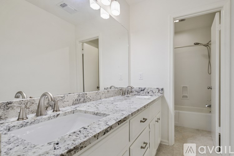 A bathroom with a marble countertop and a white sink.