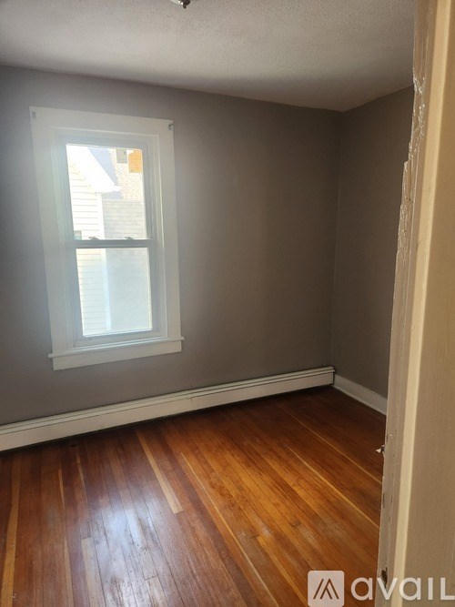 A room with a window and wooden floors.