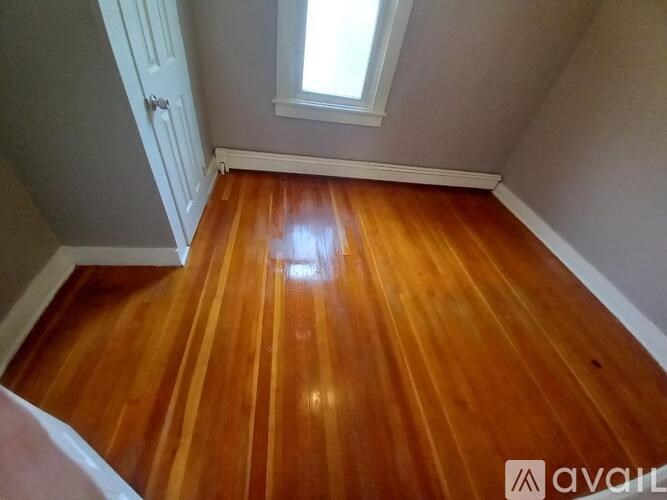 A room with wooden flooring and a skylight.