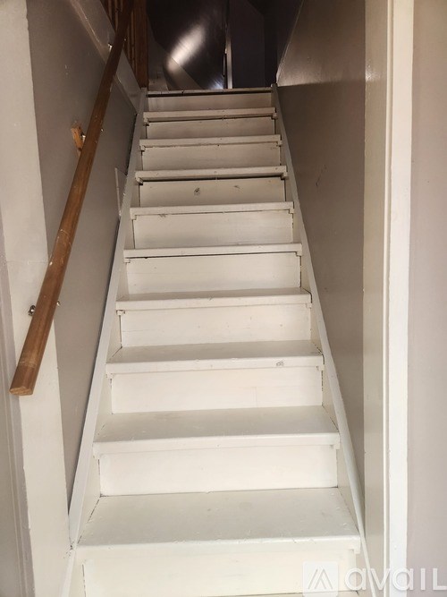 A staircase with a wooden handrail.