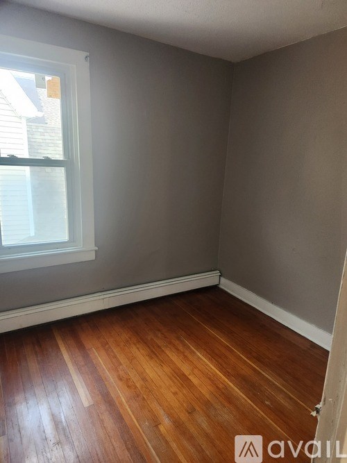 A room with wooden flooring and a window.