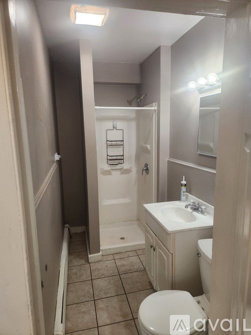 A bathroom with a toilet, sink, and mirror.