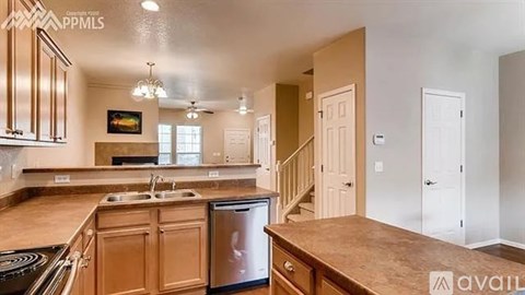 A kitchen with wooden cabinets and a stainless steel dishwasher is available for rent.