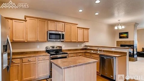 A kitchen with wooden cabinets and stainless steel appliances is available for rent.