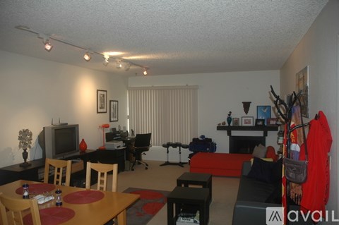 A living room with a couch, chairs, and a television.