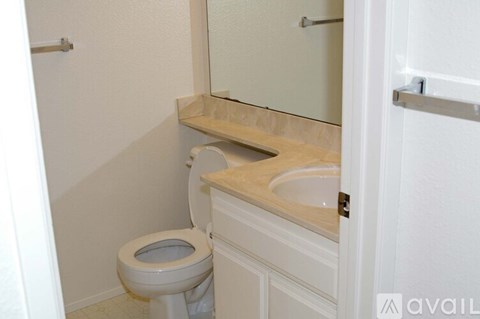 A white toilet with a sink in a small bathroom.