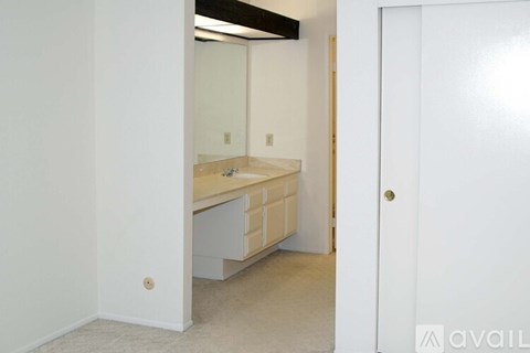 A bathroom with a vanity and mirror is shown.