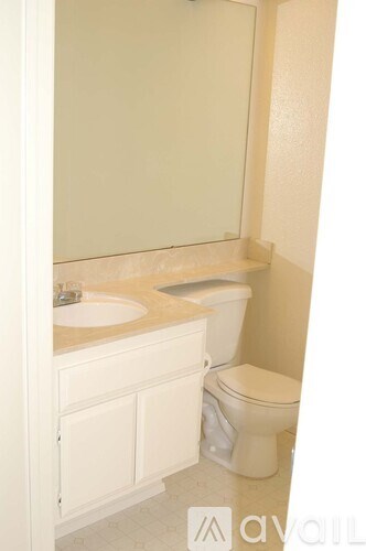 A white toilet and sink in a bathroom.