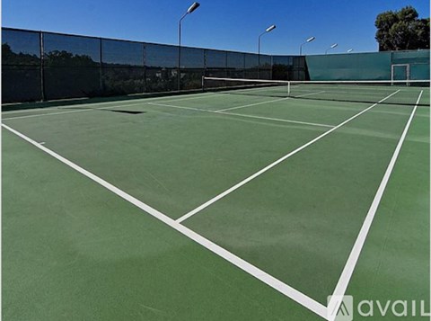 A tennis court with a net and a green surface.