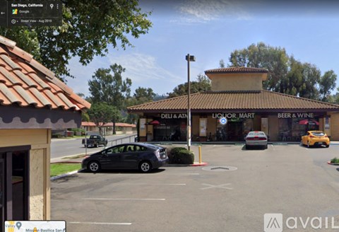 A parking lot with a liquor store in the background.