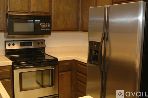 A kitchen with a stove, oven, microwave, and refrigerator.