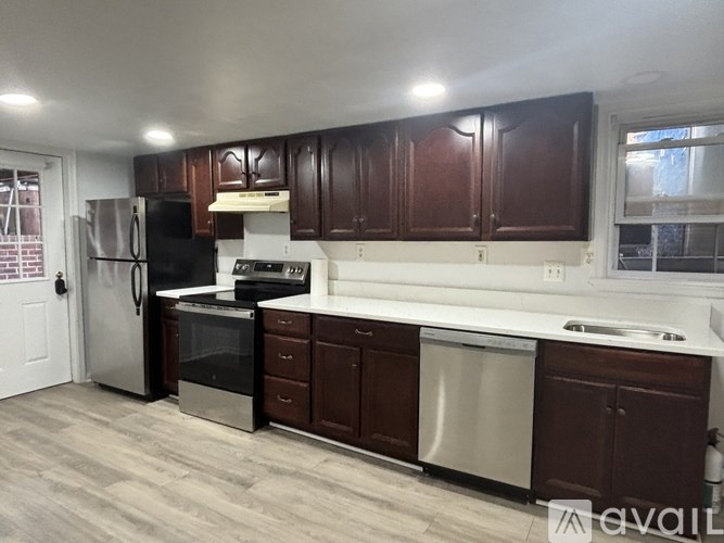 A kitchen with dark brown cabinets and stainless steel appliances.