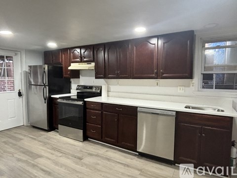 A kitchen with dark brown cabinets and stainless steel appliances.