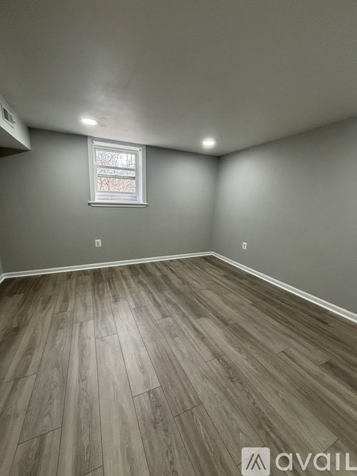 A room with wooden flooring and a window.