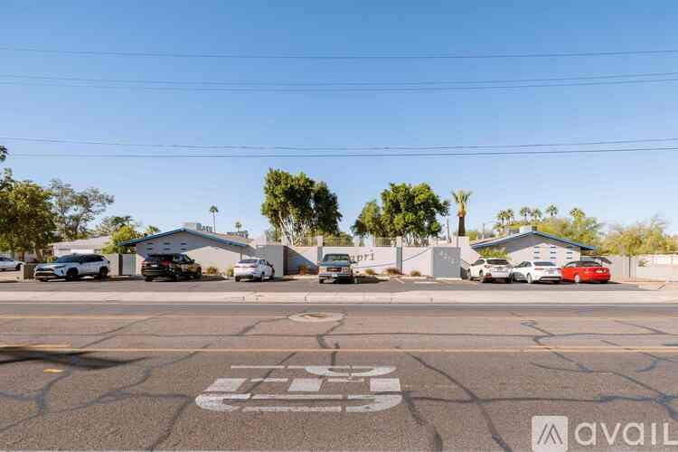 A parking lot with several cars and a building in the background.