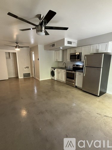 A kitchen with a refrigerator, microwave, and oven.