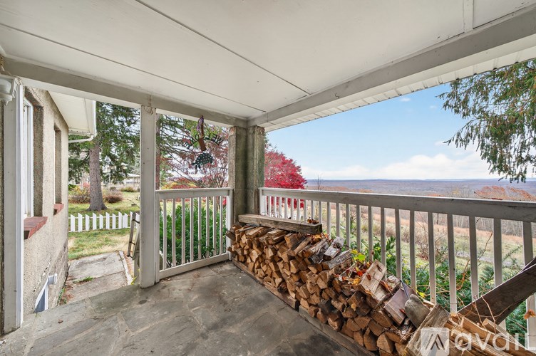 A balcony with a pile of wood logs on it.