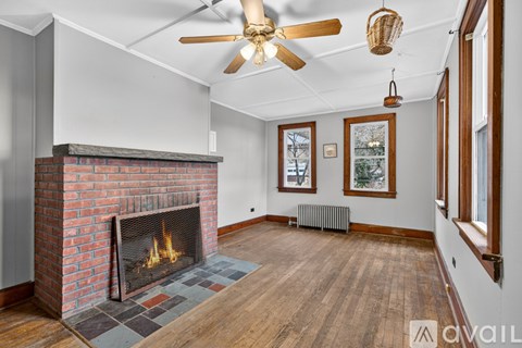 A living room with a fireplace and a ceiling fan.