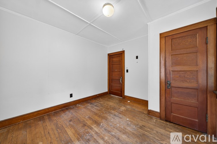 A room with a wooden floor and a wooden door.
