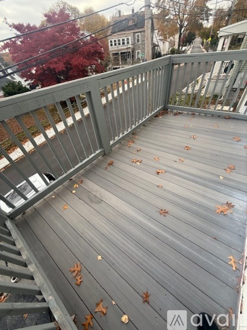 A wooden deck with fallen leaves on it.