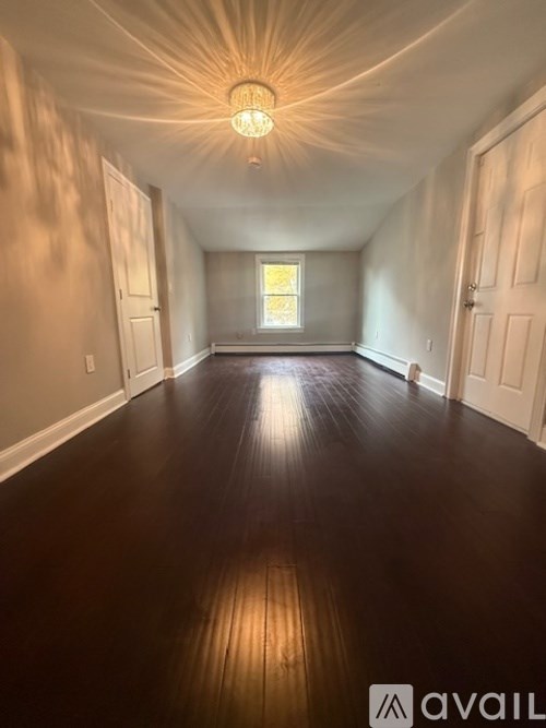 A long hallway with wooden floors and white walls.