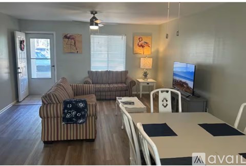 A living room with a striped couch and a television on a stand.