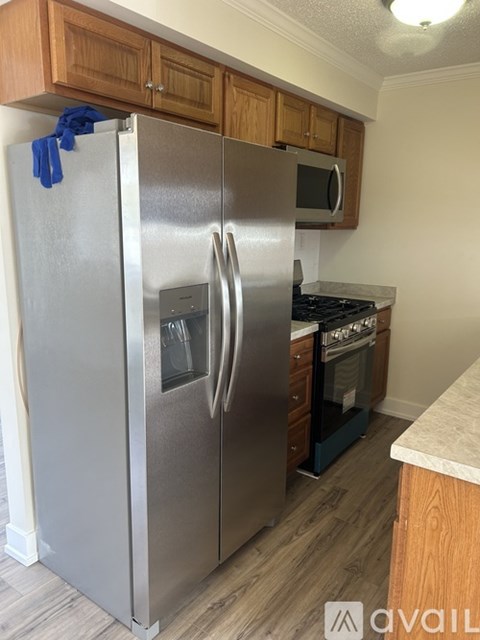A stainless steel refrigerator with a blue towel hanging on it.
