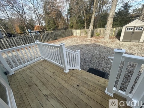 A deck with a white railing and wooden floor.