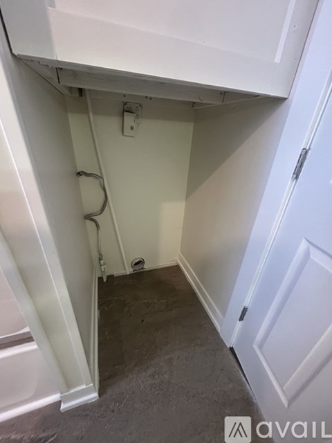 A white cabinet is open to reveal a dark floor.