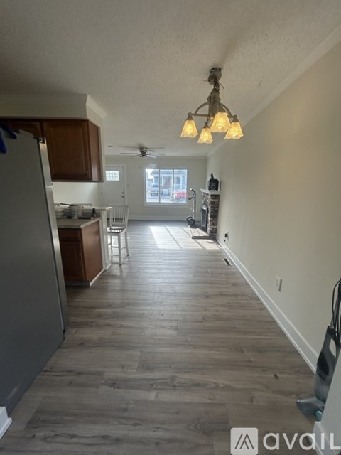 A kitchen with wooden floors and a ceiling fan.