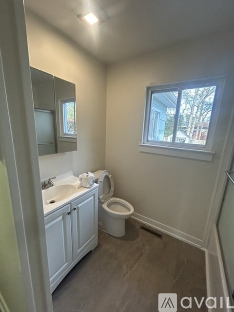 A bathroom with a toilet, sink, and mirror.