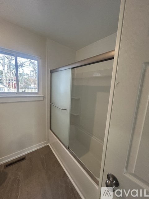 A white door with a silver handle is open.