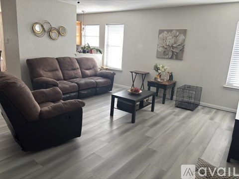 A living room with a brown couch and a wooden coffee table.