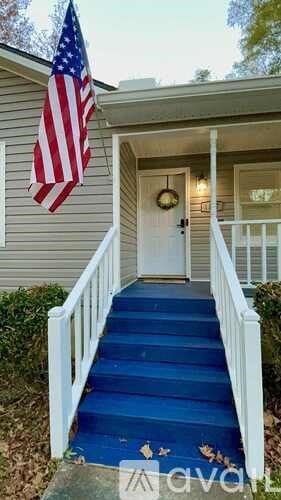 A house with a blue staircase and an American flag hanging on the wall.