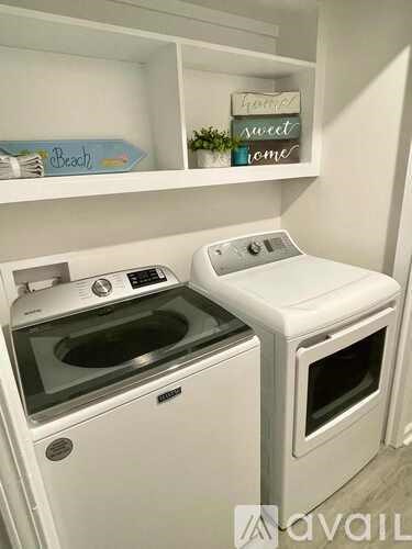 A white dishwasher and dryer are in a small kitchen.