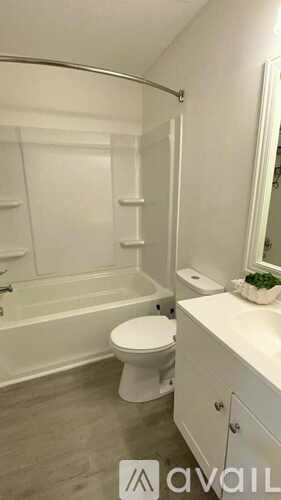 A white bathroom with a toilet, sink, and bathtub.