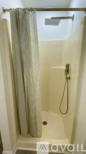 A shower area with a curtain and a shower head.