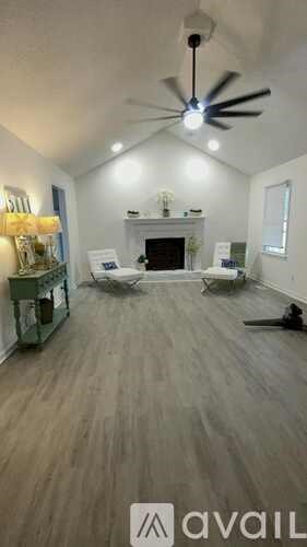 A living room with a fireplace and a ceiling fan.