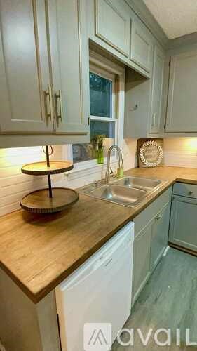 A kitchen with a wooden countertop and white cabinets.