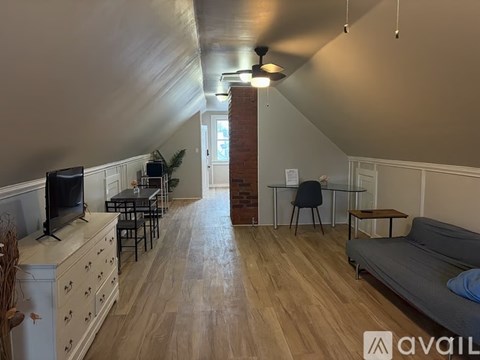 A living room with a grey couch and a wooden floor.
