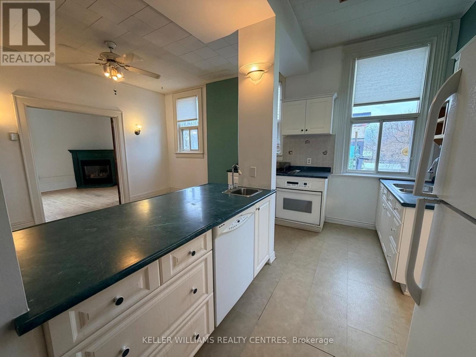 A kitchen with white cabinets and a black countertop.
