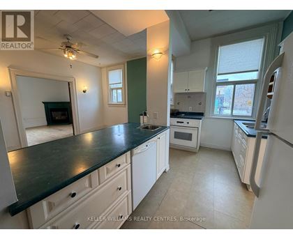 A kitchen with white cabinets and a black countertop.