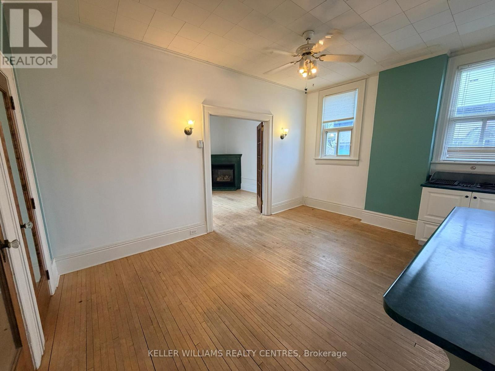 A room with a wooden floor and a ceiling fan.