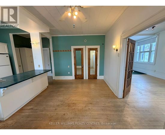 A spacious room with wooden floors and a large window.