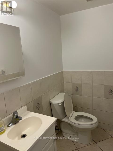 A white toilet sits next to a sink in a small bathroom.