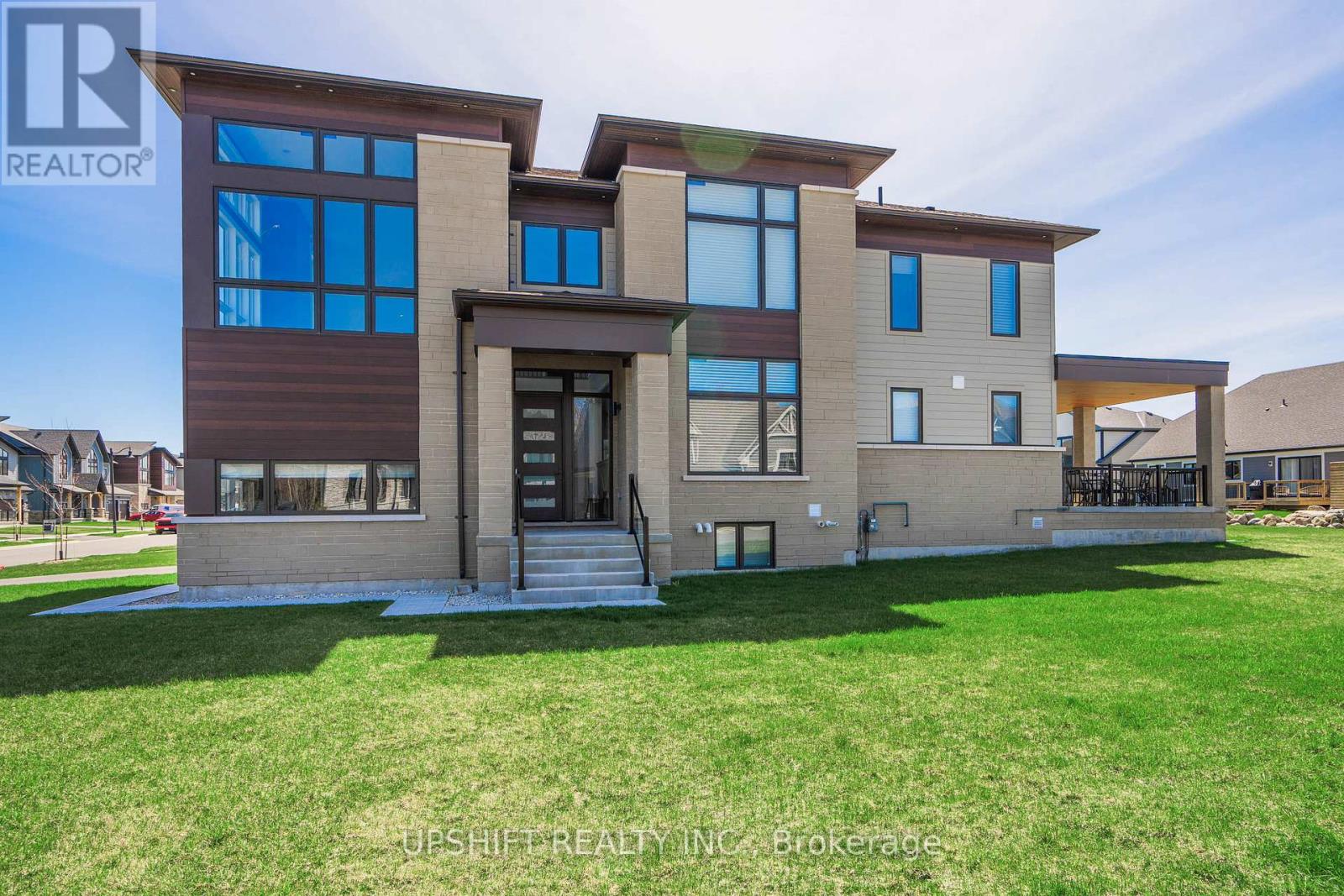 A modern house with a large front yard is for sale.