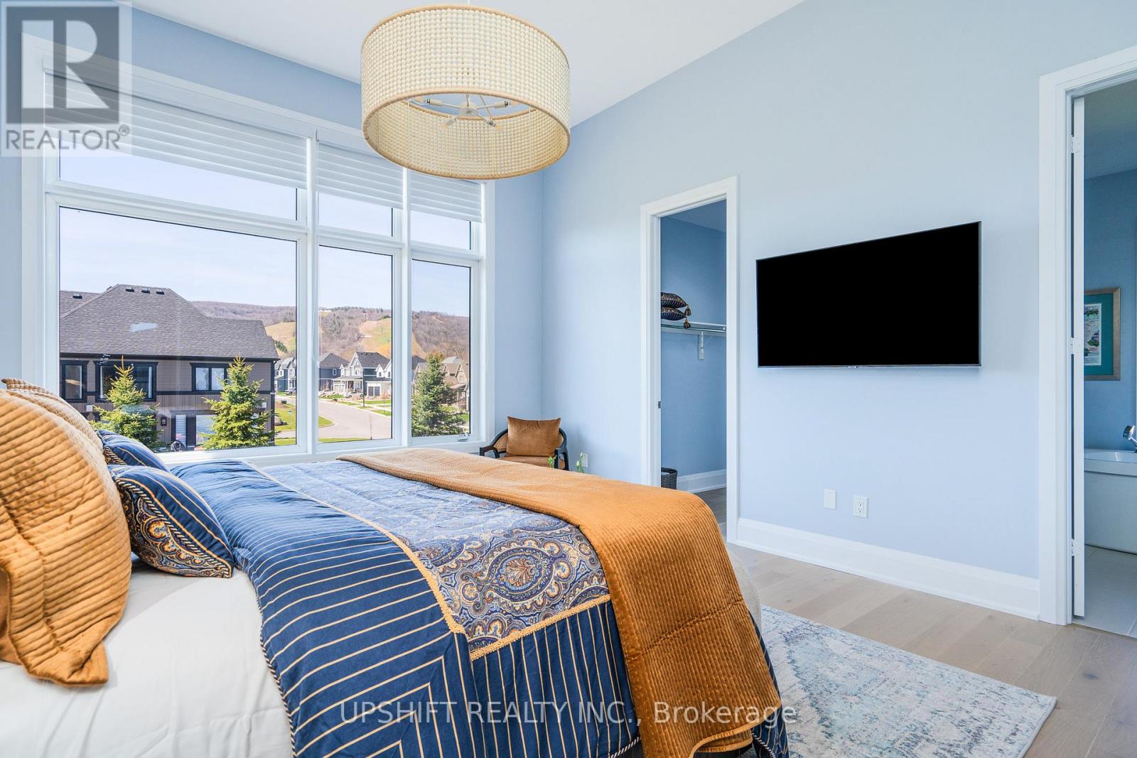 A bedroom with a large bed and a flat screen TV.