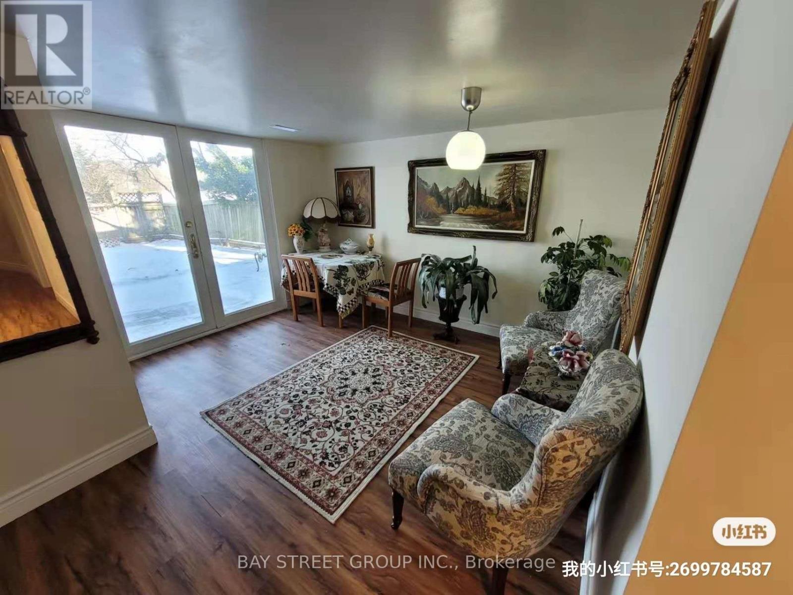 A living room with a couch, chairs, and a rug.