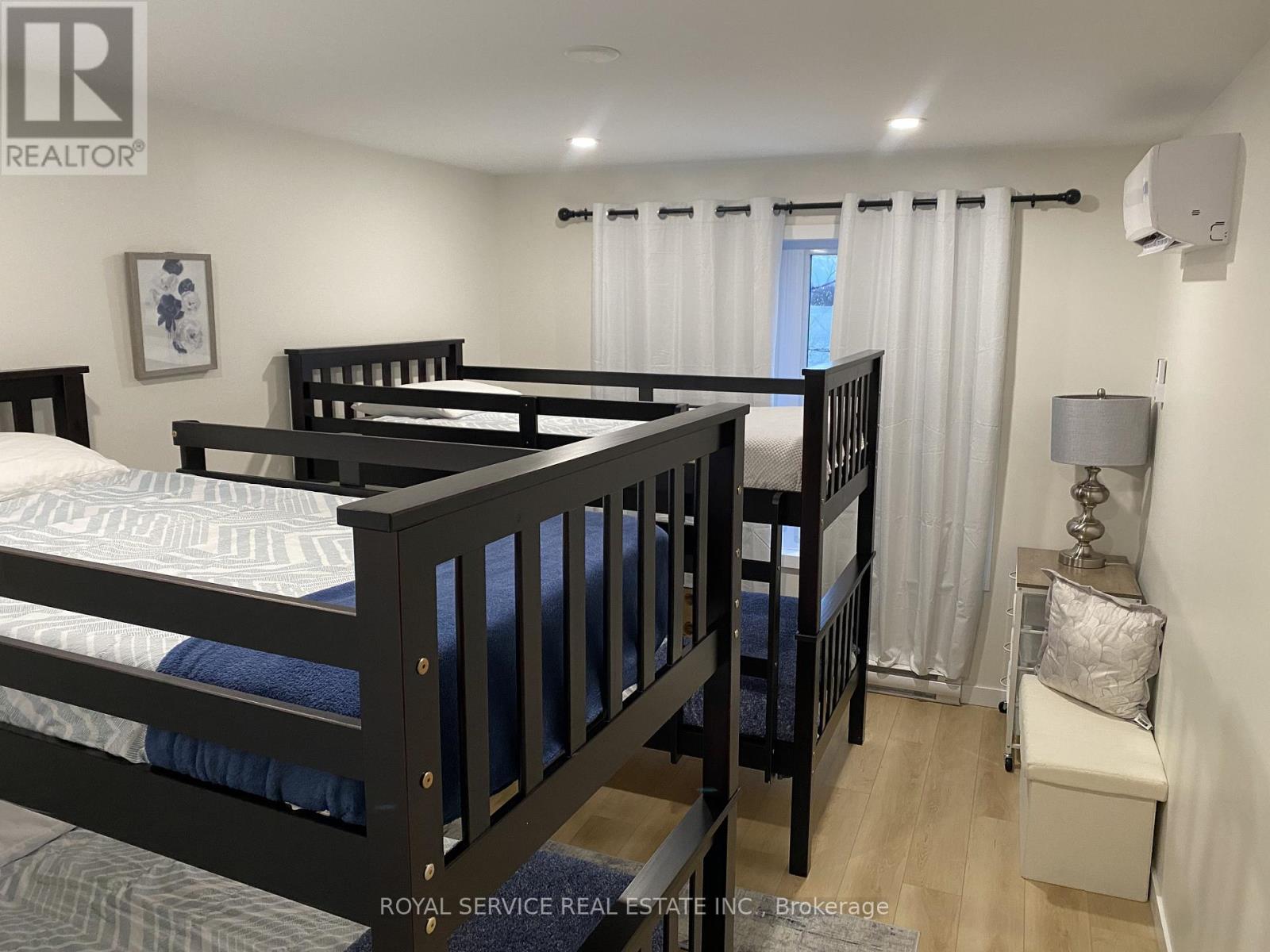 A bedroom with two beds and a nightstand.